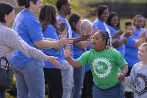 image of a woman giving a high five to young special olympics athlete.